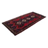 LARGE SHIRAZ RUG WITH A CHAIN OF FOUR WHITE GROUND DIAMOND SHAPED CENTRE MEDALLIONS, on a black