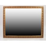 MODERN GILT FRAMED LARGE BEVEL EDGED WALL MIRROR, the frame moulded with meandering, fruiting vines,