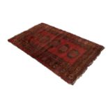 SEMI ANTIQUETURKOMAN RUG, with central row of five large guls on a wine red field, multiple border