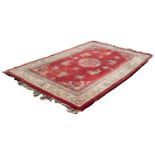 CHINESE CARPET WITH CENTRE CIRCULAR FLORAL MEDALLION on a red field decorated with floral sprays and