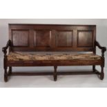 EIGHTEENTH CENTURY OAK SETTLE, the four panelled back above downswept arms with turned supports