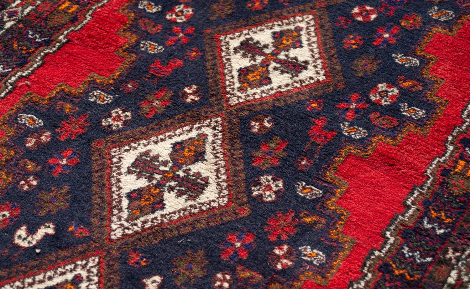 LARGE SHIRAZ RUG WITH A CHAIN OF FOUR WHITE GROUND DIAMOND SHAPED CENTRE MEDALLIONS, on a black - Image 2 of 4