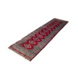 PAKISTAN TURKOMAN STYLE RUNNER with a row of twelve diamond shaped medallions on a crimson field,