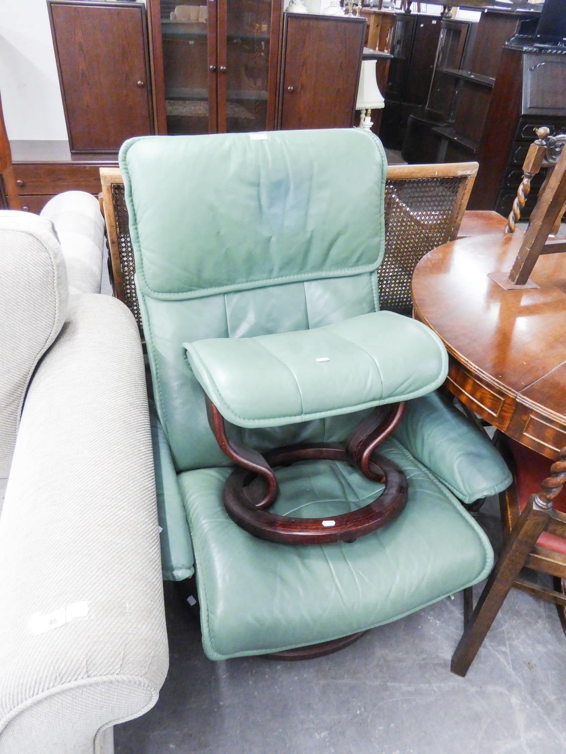 GREEN HIDE EASY ARMCHAIR, revolving on a circular wooden base and the matching footstool, (2)