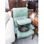 GREEN HIDE EASY ARMCHAIR, revolving on a circular wooden base and the matching footstool, (2)