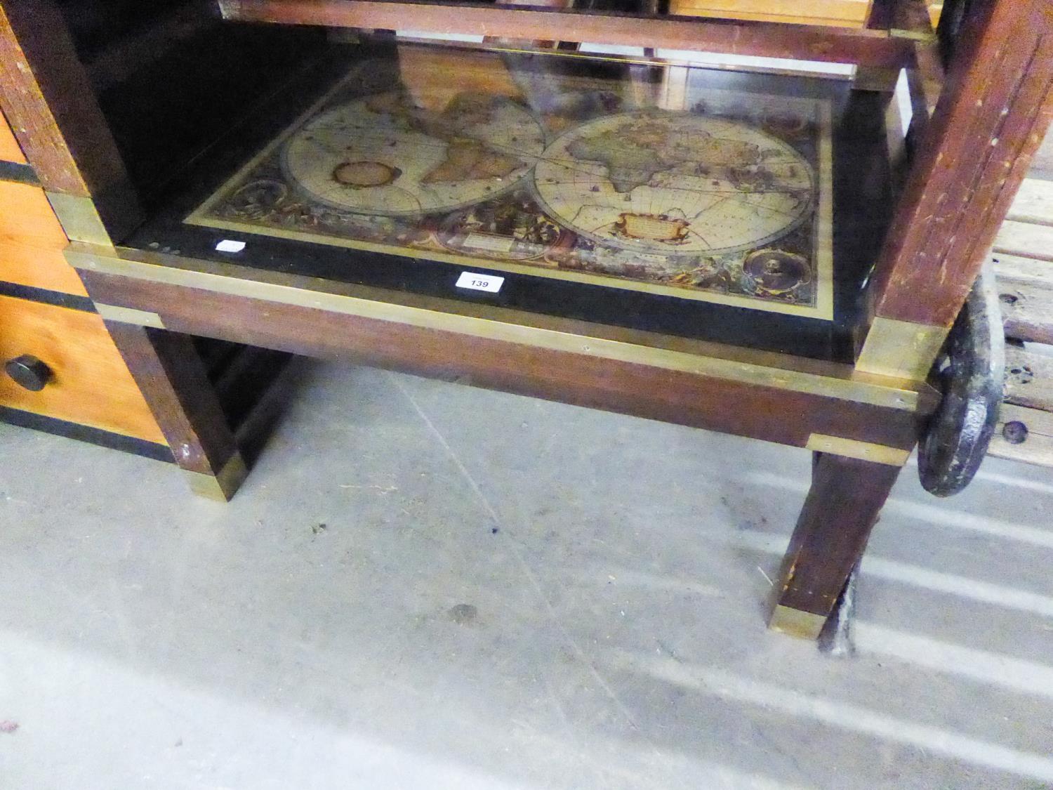 A MAHOGANY OBLONG COFFEE TABLE WITH GLASS ‘MAP’ TOP WITH BRASS BOUND EDGES, ‘H’ STRETCHERS