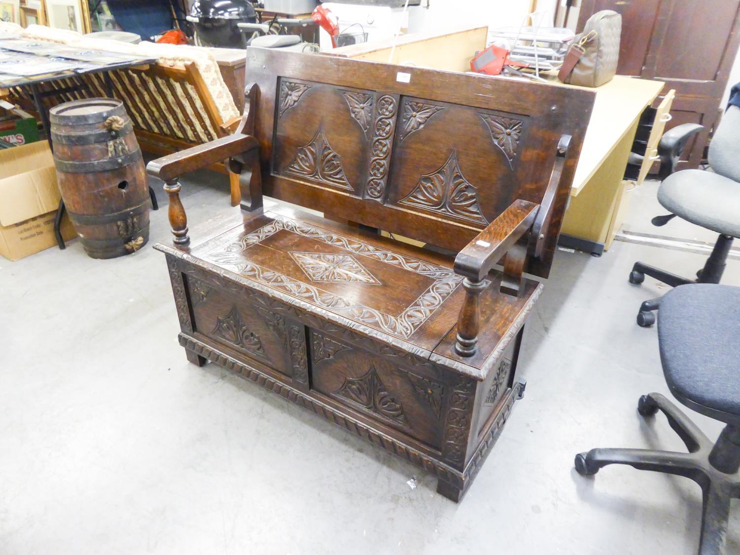 A CARVED OAK MONKS BENCH