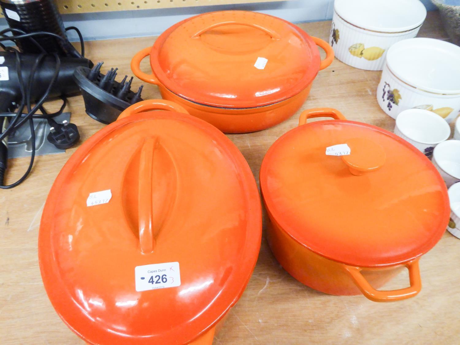 THREE ORANGE CAST IRON CASSEROLE POTS ALL WITH LIDS