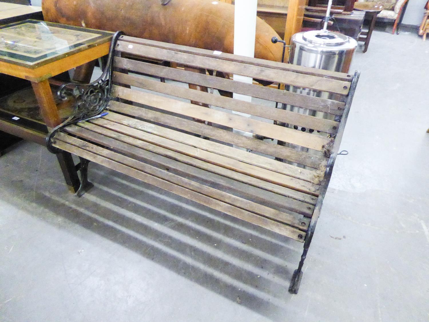 A GARDEN BENCH WITH DECORTIVE METAL SIDE WITH SLATS