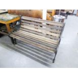 A GARDEN BENCH WITH DECORTIVE METAL SIDE WITH SLATS