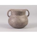 AN INTERESTING POSSIBLY ANCIENT TWO HANDLED BURNISHED CLAY POT, 3 1/2" (9cm) HIGH