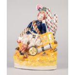 STAFFORDSHIRE POTTERY FIGURE OF A HIGHLAND SOLDIER, modelled seated against a drum, on a floral