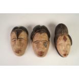 THREE AFRICAN MINIATURE CARVED AND PAINTED WOODEN SOUVENIR TRIBAL MASKS (3)