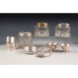 THREE CYLINDRICAL CUT GLASS DRESSING TABLE JARS WITH PULL-OFF SILVER COVERS, together with THREE