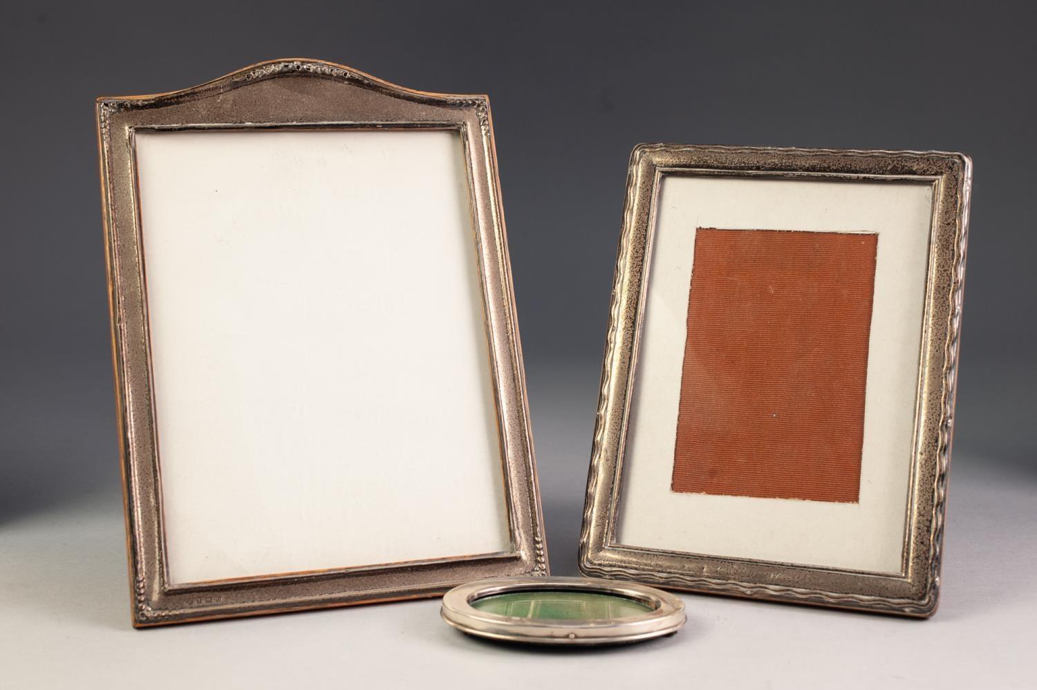 THREE GEORGE V AND LATER SILVER FRONTED PHOTOGRAPH FRAMES WITH EASEL SUPPORTS, comprising: one