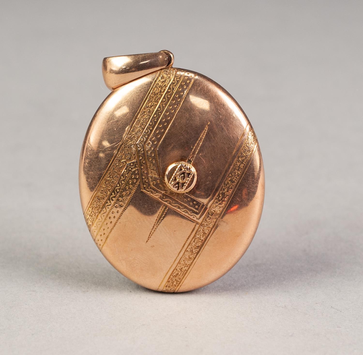 VICTORIAN (UNMARKED) GOLD COLOURED METAL ENGRAVED OVAL LOCKET PENDANT enclosing two Victorian