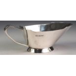 GEORGE VI STYLISH PLAIN SILVER SAUCE BOAT, of footed form with angular scroll handle, Sheffield