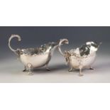 PAIR OF INTER-WAR YEARS SILVER SAUCE BOATS with shaped cut-eard bordered rims, with leaf-capped