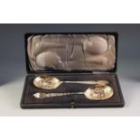 GOOD, CASED PAIR OF EDWARDIAN SILVER-GILT SERVING SPOONS, chased with leafage and scalloped