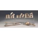 EIGHT VARIOUS SILVER NAPKIN RINGS, together with an ACORN PATTERN WHITE METAL CHILDâ€™S RATTLE ON