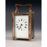 A MID TWENTIETH CENTURY BRASS CASED CARRIAGE CLOCK of typical form with oblong white dial, black