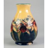 WALTER MOORCROFT ORCHID PATTERN TUBE LINED POTTERY VASE, of footed baluster form, painted in tones