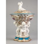TWENTIETH CENTURY CONTINENTAL PORCELAIN LIDDED DISH ON FIGURAL STAND, the shallow dish with seated