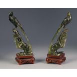 PAIR OF ORIENTAL CARVED JADE COLOURED GREEN HARDSTONE MODELS OF EXOTIC PERCHED BIRDS, 8 ¾? (22.