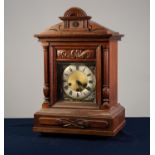 LATE 19th/EARLY 20th CENTURY GERMAN WALNUT CASED MANTEL CLOCK with carved ornament, the Junghans