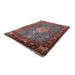SEMI ANTIQUE HAND WOVEN CARPET with petal shaped centre medallion on a sky blue field and a