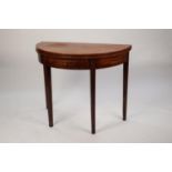 EARLY NINETEENTH CENTURY MAHOGANY DEMI-LUNE TEA TABLE, the fold-over top set above a conforming