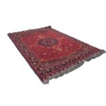 AN ATTRACTIVE SEMI-ANTIQUE TURKISTANI WOOL PILE CARPET, overall predominately red and indigo, the