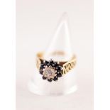 18ct GOLD CLUSTER RING SET WITH A SMALL CENTRE DIAMOND in a deceptive setting and surround of ten