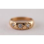 18ct GOLD DIAMOND THREE STONE RING. Star set graduated old cut diamonds, to a tapered shank, total