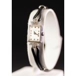 AN 18ct GOLD CASED MAURICE GUERDAT LADY'S WRIST WATCH, set with eight tiny diamonds, on a black