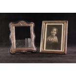 MODERN EMBOSSED SILVER FRONTED PHOTO FRAME with oblong aperture and shaped outer border on blue