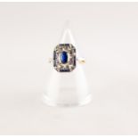 EDWARDIAN SAPPHIRE AND DIAMOND PLAQUE RING. An oval cut sapphire within a pierced plaque set with