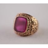 9ct GOLD SYNTHETIC RUBY RING. A rectangular synthetic ruby plaque, in a rubbed over setting, to a