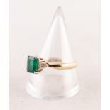 A GOLD (no carat mark) RING, set with an emerald between shoulders set with six tiny diamonds, 4.