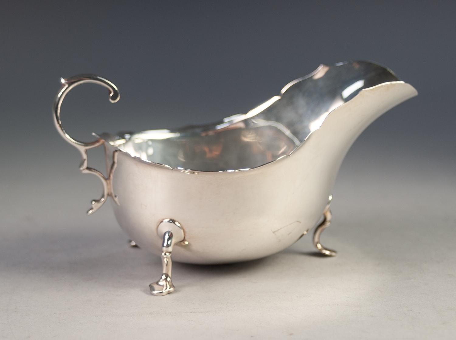 AN EDWARDIAN SILVER SAUCE BOAT, with everted cut rim, flying scroll handle standing on three trefoil - Image 2 of 3