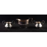 PAIR OF EDWARDIAN SILVER TWO HANDLE SMALL CREAM MEASURES with double 'C' scroll handles,