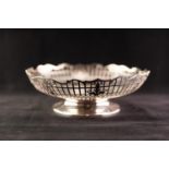 A TWENTIETH CENTURY SILVER PIERCED LOW PEDESTAL BOWL, with scrolliated rim, Sheffield 1943, 15 1/2oz