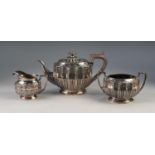 THREE PIECE ELECTROPLATED TEA SET BY WALKER & HALL, of part fluted oval form, with angular scroll