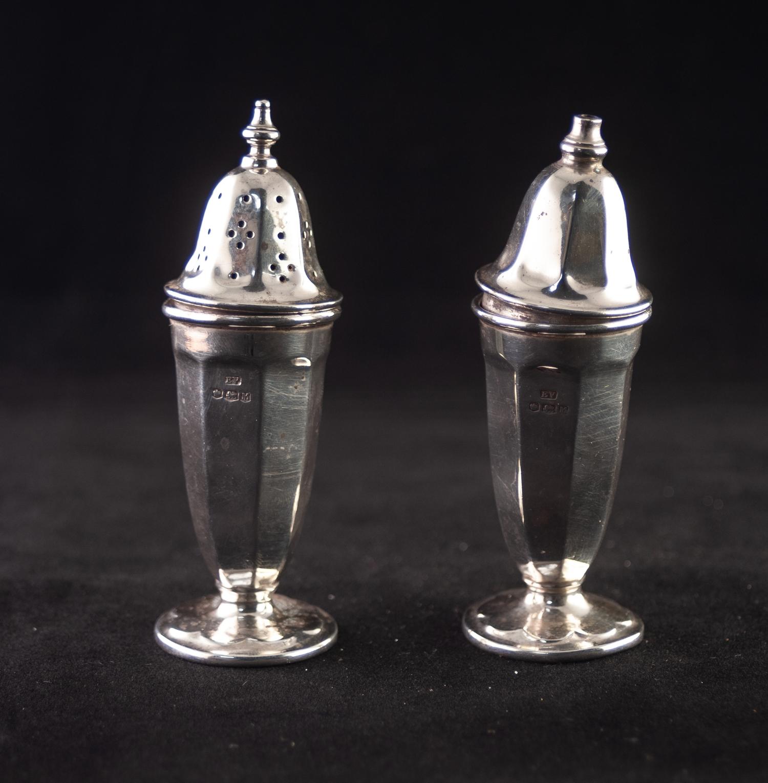 A PAIR OF TALL SILVER CONDIMENTS, of panelled vase form with removable tops, one pierced for pepper,