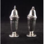 A PAIR OF TALL SILVER CONDIMENTS, of panelled vase form with removable tops, one pierced for pepper,