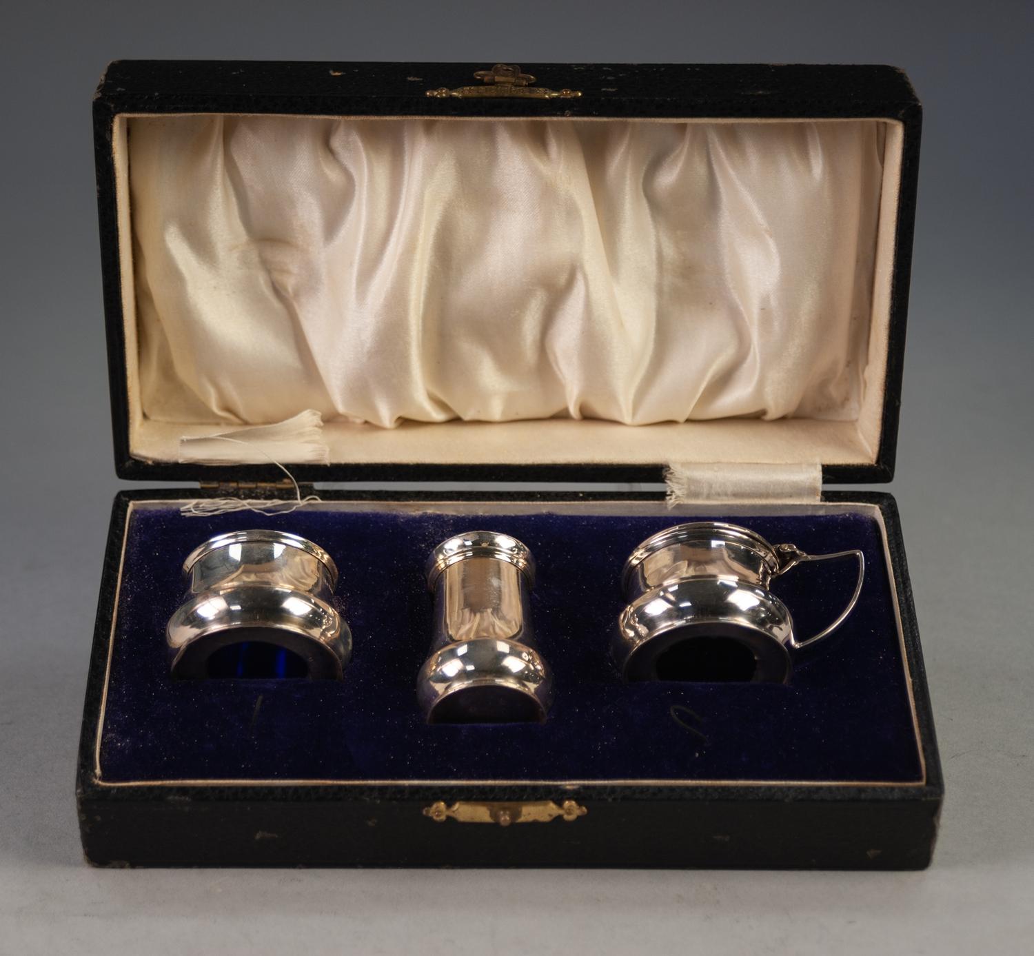 George V BOXED SILVER CONDIMENT TRIO of plain early Georgian style with blue glass liners (lacks