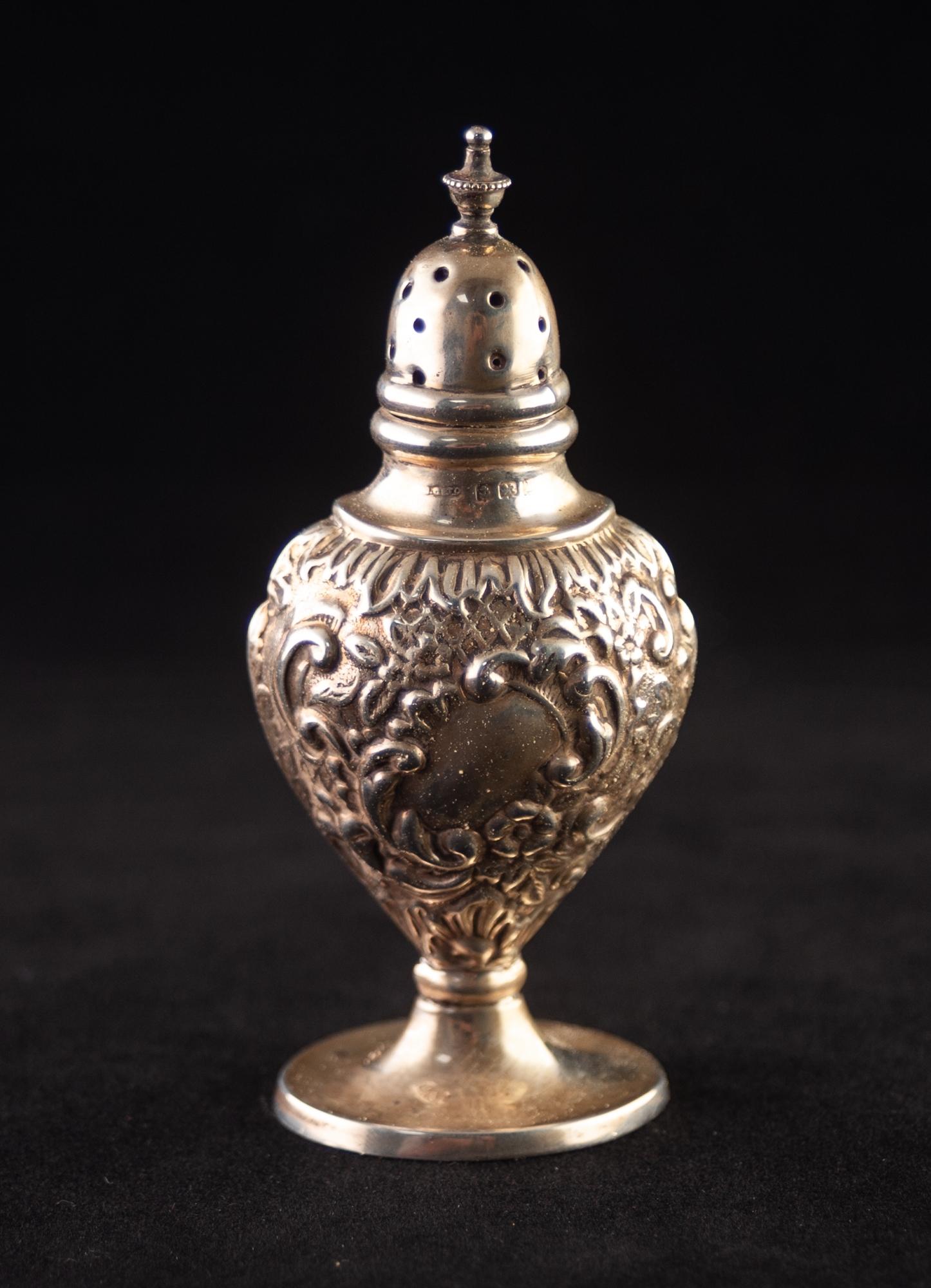 AN EARLY TWENTIETH CENTURY SILVER PEDESTAL PEPPERETTE, stamped with scrollwork, shellwork,