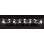 A SET OF FOUR EDWARDIAN SILVER OVAL SALT CELLARS (no liners) repousse decorated with foliate