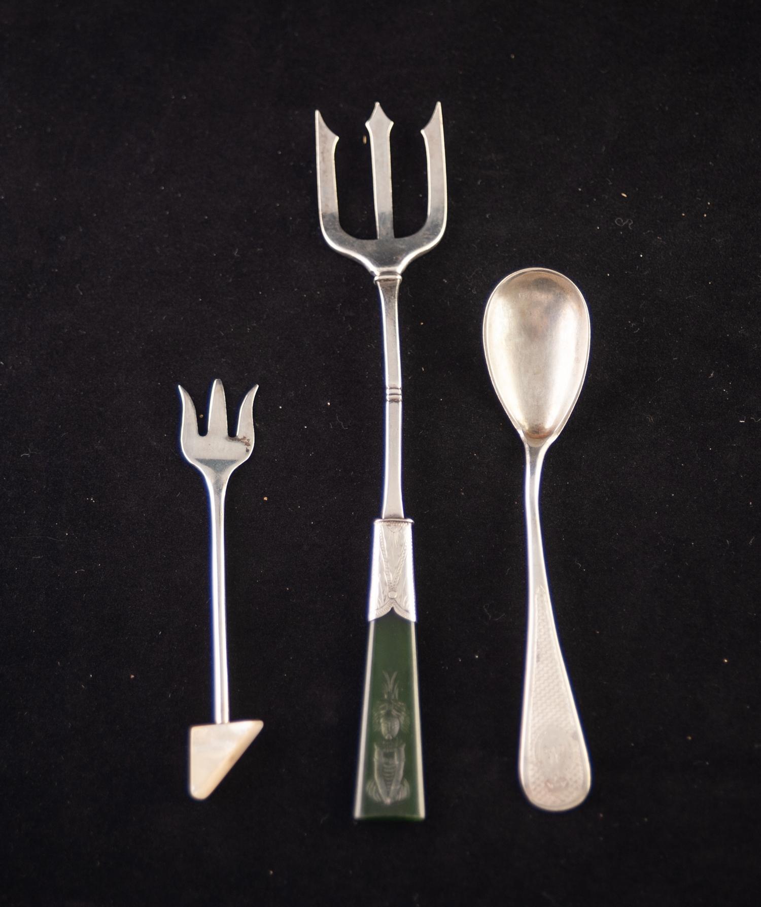 AN EARLY TWENTIETH CENTURY STERLING SILVER PICKLE FORK, with green jade handle, carved in intaglio