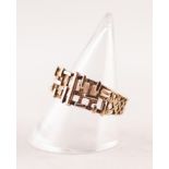 GOLD COLOURED METAL RING WITH RANDOM PATTERN BROAD PIERCED AND EMBOSSED TOP, resllis pierced